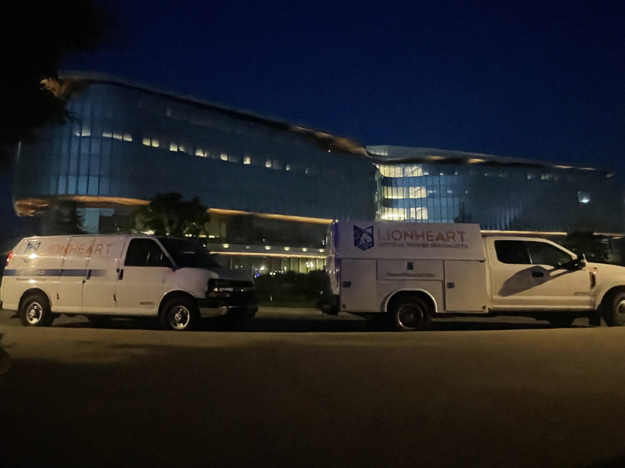 Two LionHeart service trucks parked in the night time