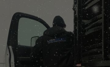 back of lionheart employee getting into a truck in the snow