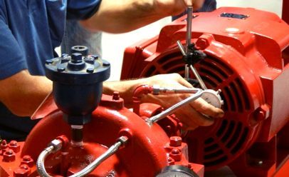 close up of man's hands working a red fire pump