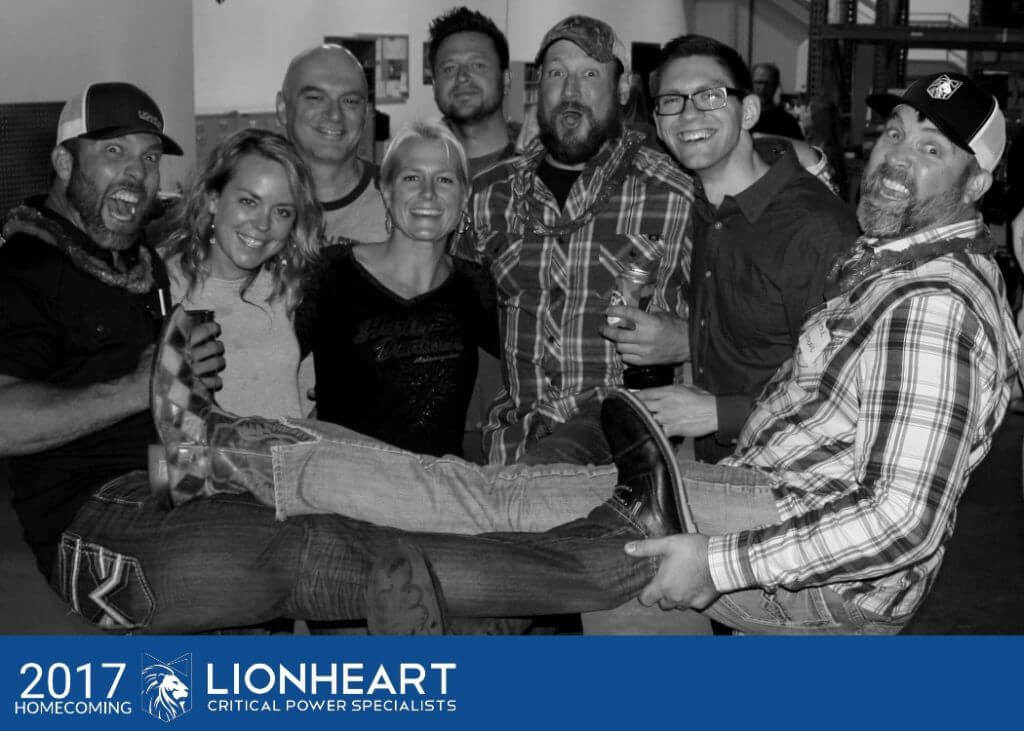 eight employees smiling for the camera at the lionheart 2017 homecoming