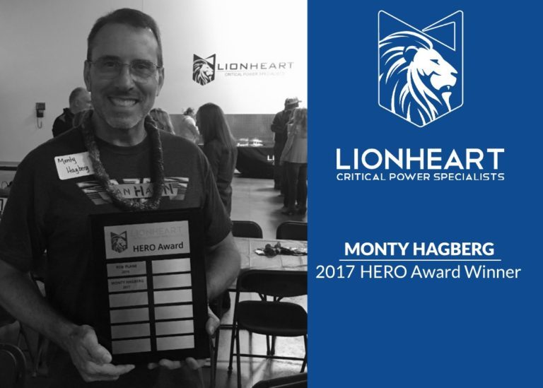 employee monty hagberg holding his hero award plaque