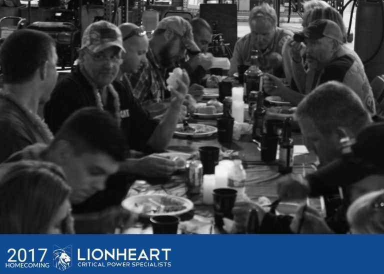 lionheart employees gathered around a long table talking and eating